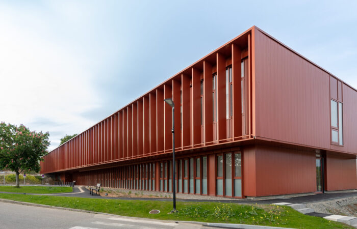 Vue extérieure du Centre Hospitalier de Douarnenez, un projet d'architecture médicale d'A26, mettant en avant la durabilité et l'efficacité énergétique avec son design moderne et ses espaces verts intégrés.